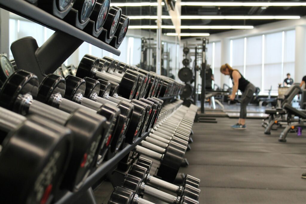 Sesión fotográfica de fitness con atleta en gimnasio iluminación profesional